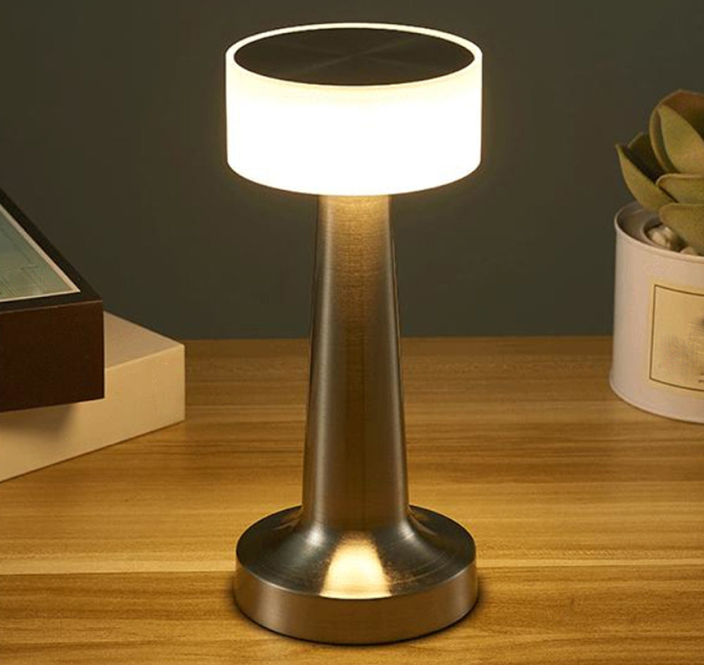 lampe de chevet doree allumee sur petite table en decoration